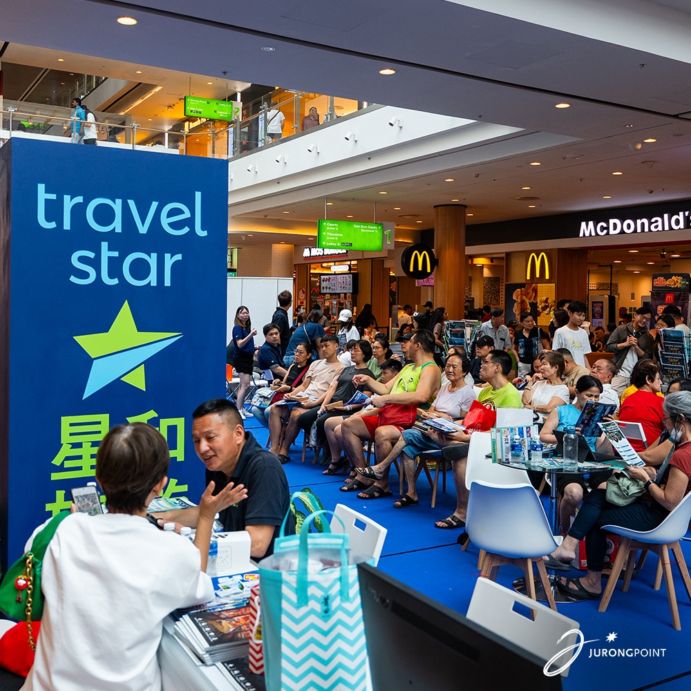 People browsing travel deals at a bustling fair