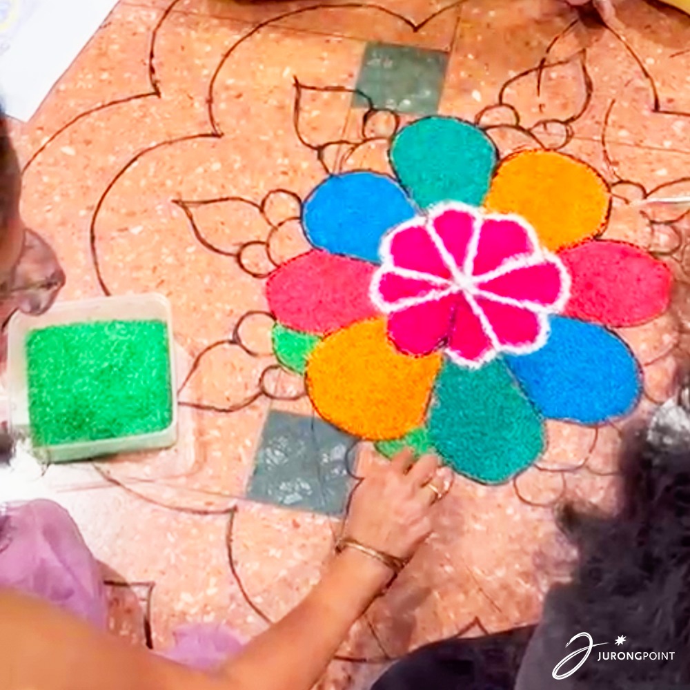 A vibrant rangoli design being created or displayed.