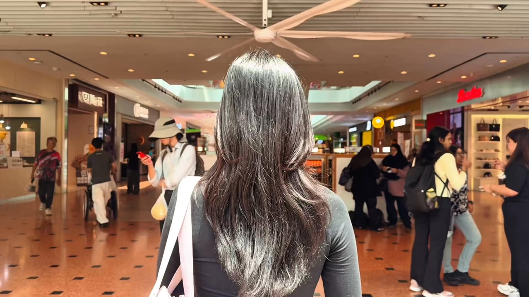 Jurong Point shopping mall corridor with luxury brand storefronts including Burberry and Gucci